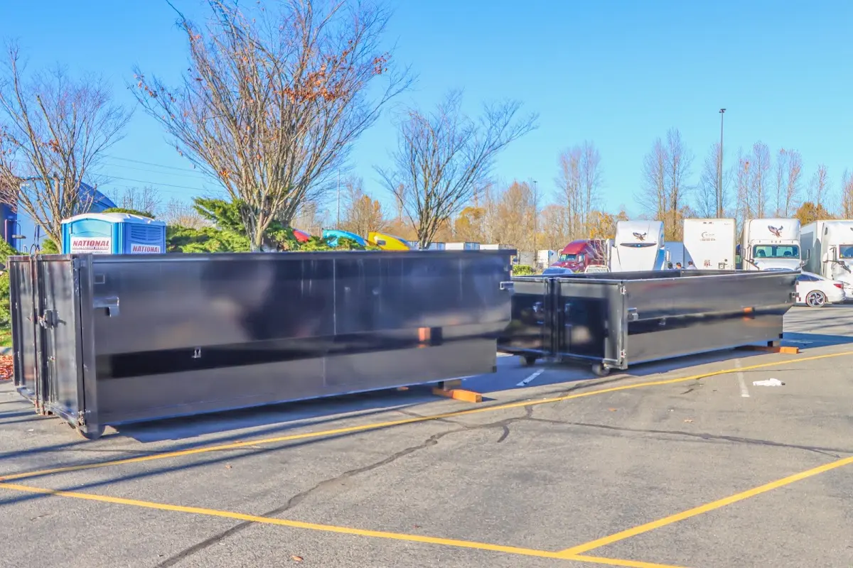 Professional dumpster rental service with roll-off container on residential driveway in Alvin